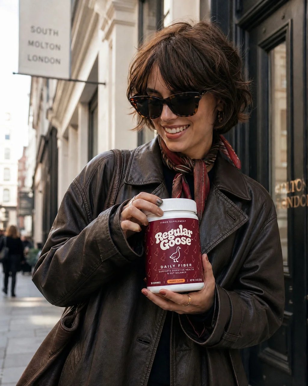 A woman on a London street holding a jar of Regular Goose Daily Fiber